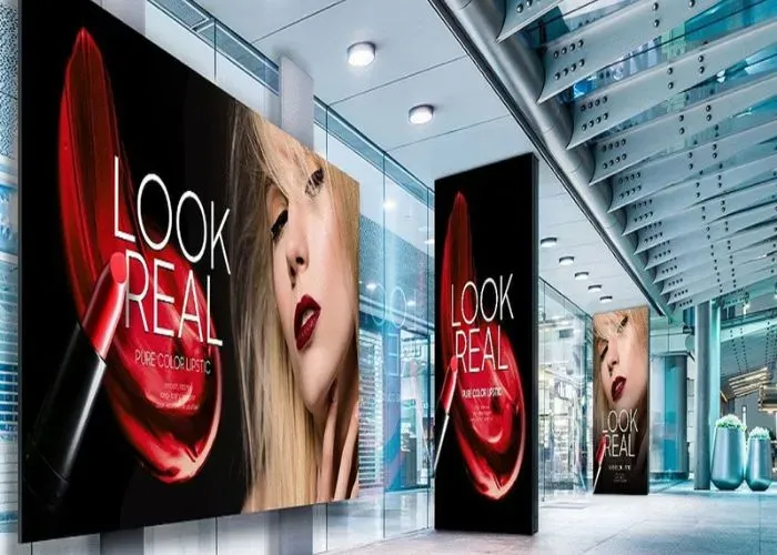 Customizable LED screen walls inside a shopping mall displaying a fashion brand advertisement.