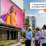 Indian professionals inspecting a led wall outdoor installation on a modern commercial building for high-visibility digital advertising.