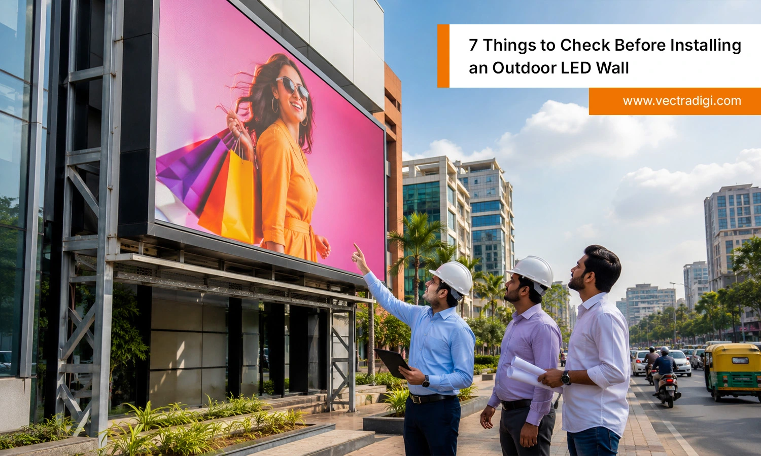 Indian professionals inspecting a led wall outdoor installation on a modern commercial building for high-visibility digital advertising.
